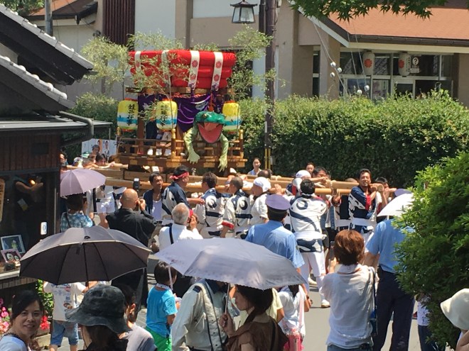 The festival is a community event with two floats involved, both containing a frog. One involved the children of the area surrounding the temple. The other float, shown here, was carried past and then to the temple by a group of local men.