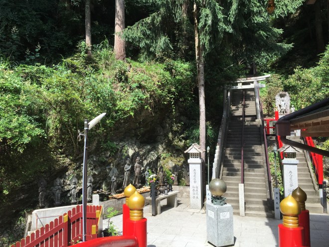 At the bottom of the steps one comes to a vermillion bridge that leads to the shrine. Ladels and water can be found near the statues to partake of Shinto purification ritual before entering the shrine. 